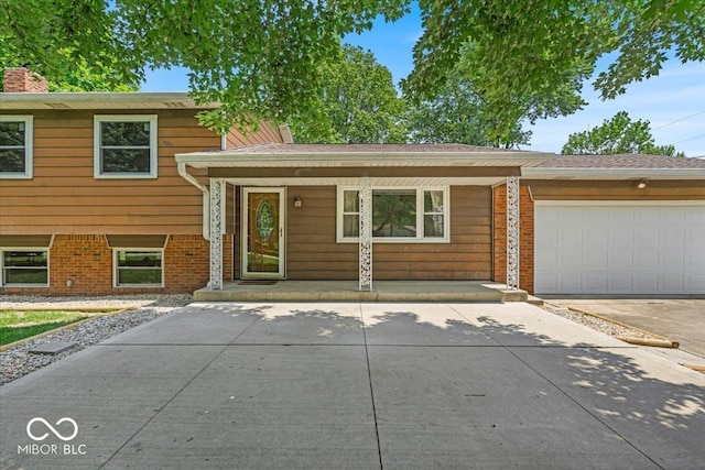 11054 N Shelby 490 W, New Palestine, IN 46163 - split level home with covered porch, brick siding, driveway, and a garage