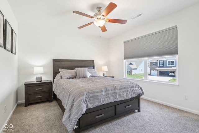 bedroom featuring visible vents, baseboards, and light carpet