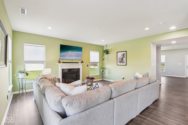 living area featuring visible vents, a wealth of natural light, and dark wood-style floors