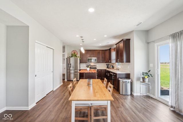 dining space featuring dark wood-type flooring, baseboards, and plenty of natural light