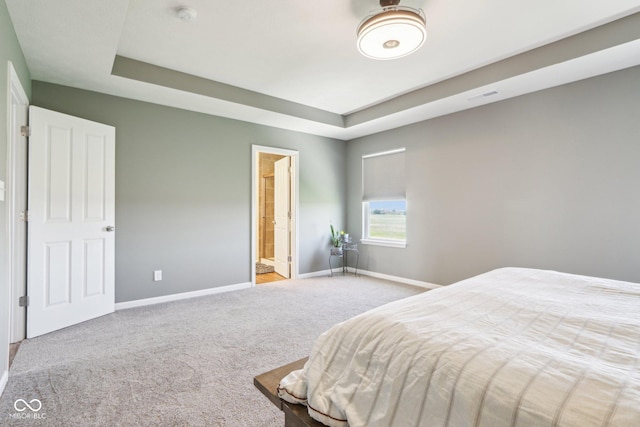 bedroom with carpet, visible vents, a tray ceiling, and baseboards