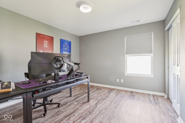 home office featuring visible vents, baseboards, and wood finished floors