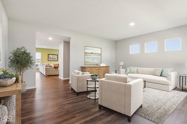 living area with dark wood-type flooring, recessed lighting, and a healthy amount of sunlight