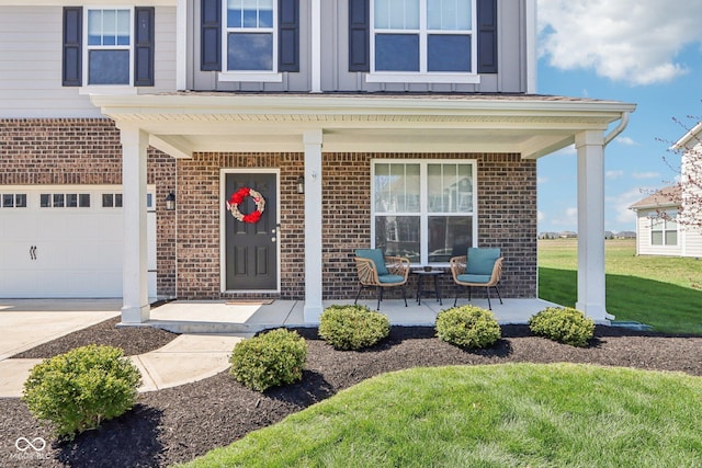view of exterior entry featuring driveway, board and batten siding, brick siding, a porch, and a lawn
