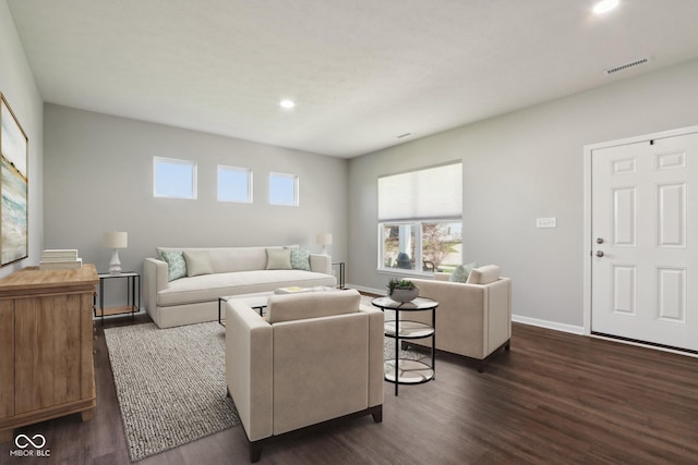 living area with recessed lighting, dark wood-type flooring, visible vents, and baseboards