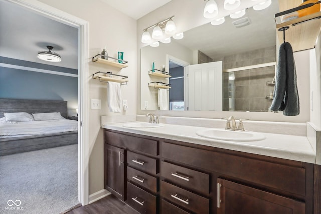 bathroom with double vanity, ensuite bathroom, a sink, and a stall shower