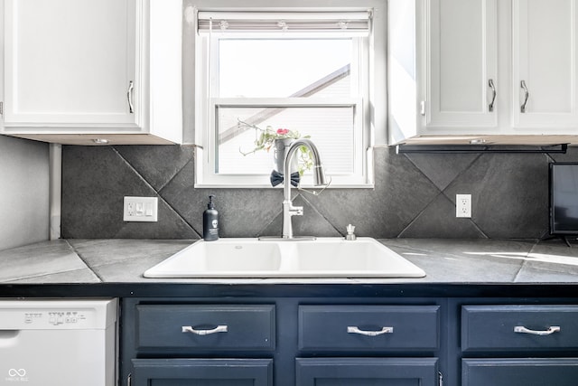 kitchen with a sink, blue cabinets, white cabinetry, and dishwasher