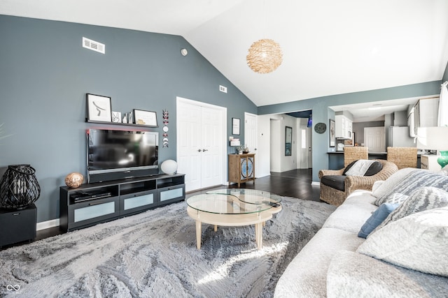living room with high vaulted ceiling, baseboards, wood finished floors, and visible vents