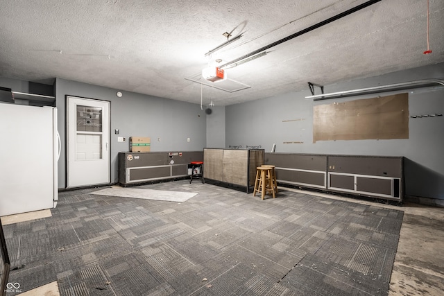 garage featuring freestanding refrigerator and a garage door opener