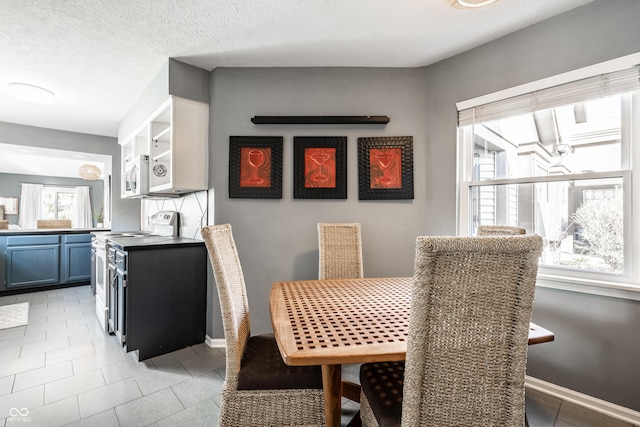 dining space featuring light tile patterned floors and baseboards