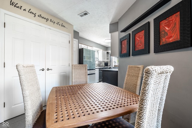 dining space featuring a textured ceiling and visible vents