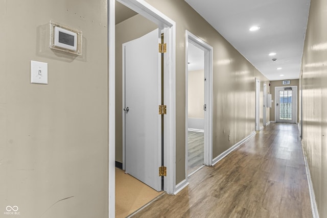corridor featuring recessed lighting, baseboards, and wood finished floors