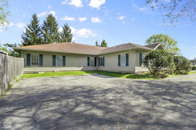 single story home featuring uncovered parking and fence