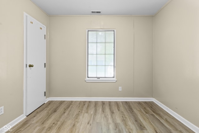 unfurnished room with baseboards, visible vents, and wood finished floors