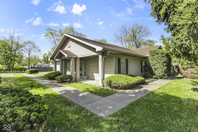 view of home's exterior with a yard, covered porch, and fence