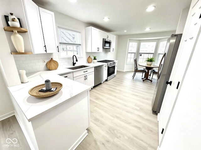 10200 Cheswick Ln, Fishers, IN 46037 - kitchen featuring a sink, stainless steel appliances, light stone countertops, white cabinets, and healthy amount of natural light