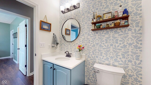 7971 Cool Hollow Pl, Indianapolis, IN 46237 - bathroom featuring wood finished floors, wallpapered walls, vanity, baseboards, and toilet