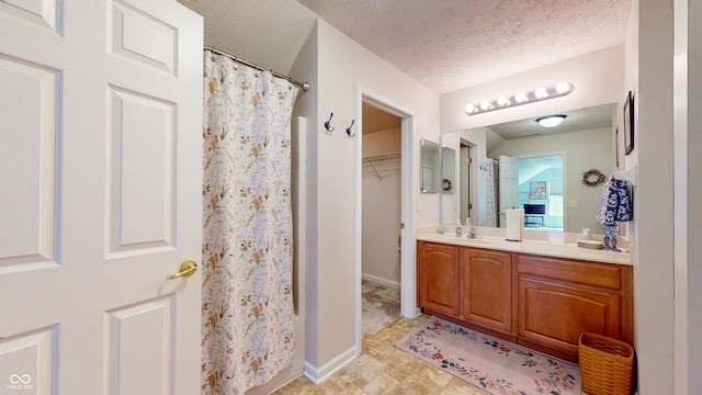 7971 Cool Hollow Pl, Indianapolis, IN 46237 - full bathroom featuring curtained shower, a spacious closet, vanity, baseboards, and a textured ceiling