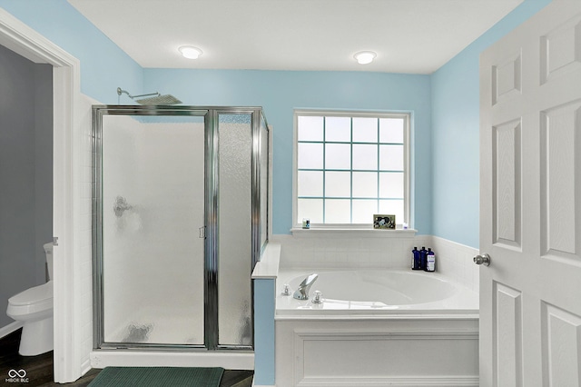 bathroom with a shower stall, a garden tub, and toilet