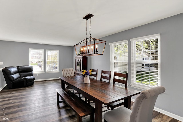 dining room featuring plenty of natural light, baseboards, and an inviting chandelier