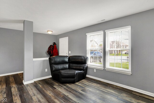 sitting room with visible vents, baseboards, and dark wood-style flooring