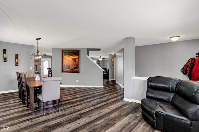 dining room with dark wood finished floors, baseboards, and a notable chandelier