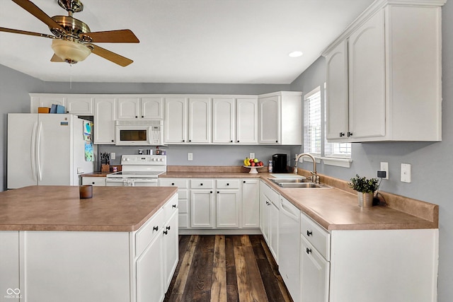 kitchen featuring white cabinets, a ceiling fan, a sink, dark wood-type flooring, and white appliances