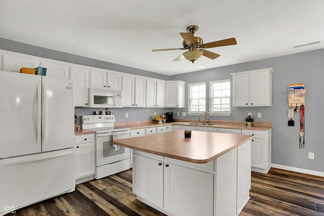 kitchen with white appliances, a sink, ceiling fan, and dark wood-style flooring