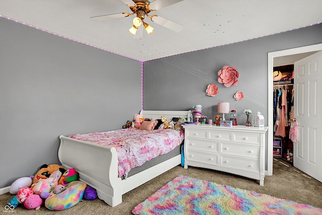 carpeted bedroom with a spacious closet, a ceiling fan, and a closet