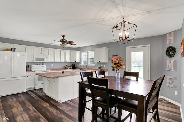 dining space with ceiling fan with notable chandelier, baseboards, and dark wood-type flooring