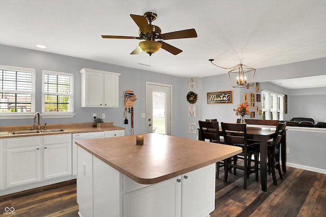 kitchen featuring white cabinets, a healthy amount of sunlight, a sink, and dark wood finished floors