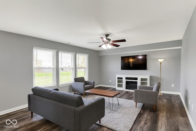 8531 Aberdeenshire Ct, Indianapolis, IN 46259 - living room featuring a ceiling fan, a glass covered fireplace, and dark wood-style flooring