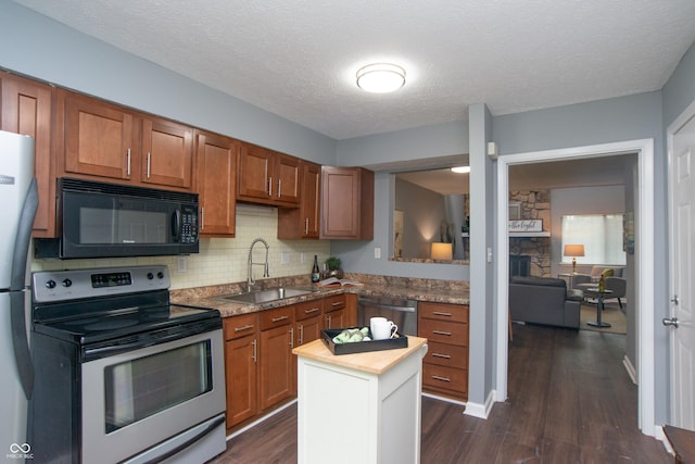 kitchen with brown cabinets, stainless steel appliances, wooden counters, and a sink
