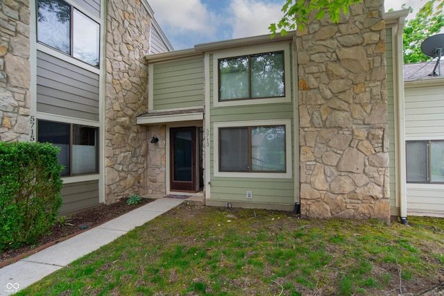 exterior space featuring a front lawn and stone siding