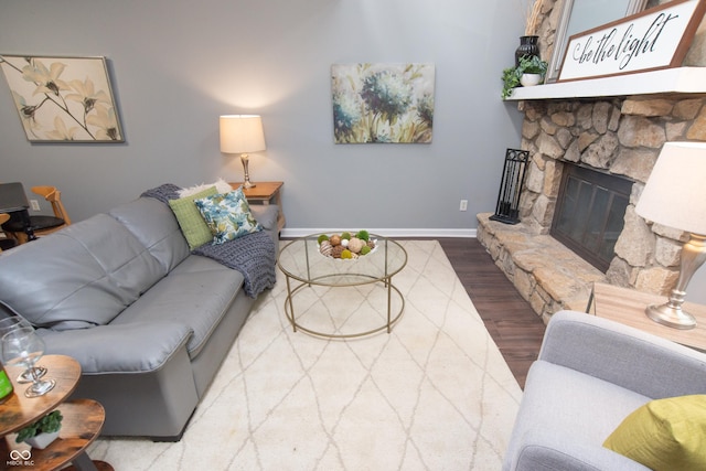 living room featuring baseboards, a fireplace, and wood finished floors
