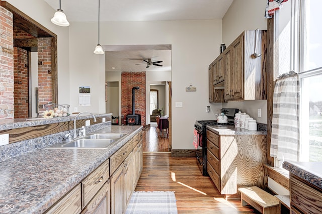 3864 N US Highway 231, Greencastle, IN 46135 - kitchen featuring hanging light fixtures, a sink, a wood stove, gas stove, and light wood-style flooring