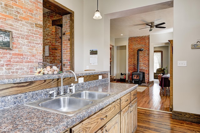 3864 N US Highway 231, Greencastle, IN 46135 - kitchen featuring a ceiling fan, a wood stove, dark wood-type flooring, decorative light fixtures, and a sink