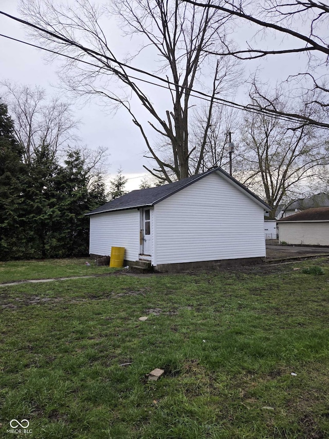 view of side of home with entry steps and a lawn