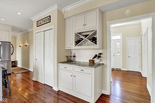 4932 Willow Ridge Ct, Zionsville, IN 46077 - bar with crown molding, baseboards, freestanding refrigerator, and dark wood-style floors