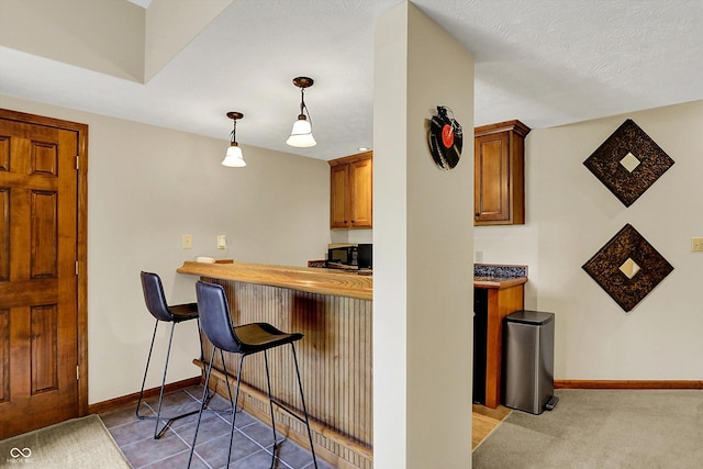 4932 Willow Ridge Ct, Zionsville, IN 46077 - bar featuring hanging light fixtures, baseboards, and black microwave