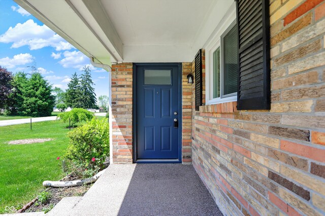 3809 Wildwood Dr, Indianapolis, IN 46239 - view of exterior entry with brick siding and a yard