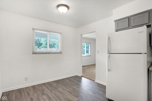 3809 Wildwood Dr, Indianapolis, IN 46239 - kitchen with freestanding refrigerator, wood finished floors, baseboards, and gray cabinetry
