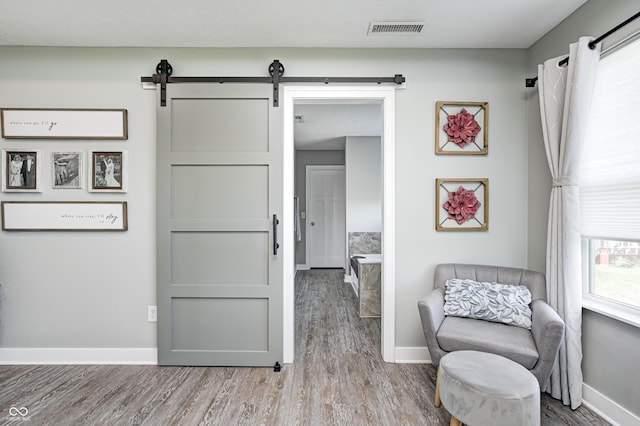 4644 Shelby Cir, Greenwood, IN 46143 - sitting room with visible vents, baseboards, a barn door, and wood finished floors