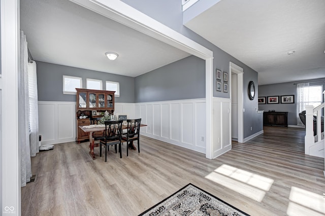 4644 Shelby Cir, Greenwood, IN 46143 - dining room featuring a decorative wall, stairway, light wood-style flooring, and a wainscoted wall