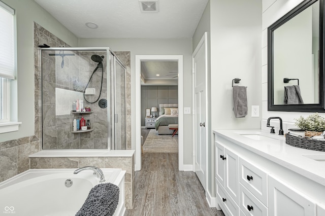4644 Shelby Cir, Greenwood, IN 46143 - ensuite bathroom with visible vents, a sink, wood finished floors, a stall shower, and a garden tub