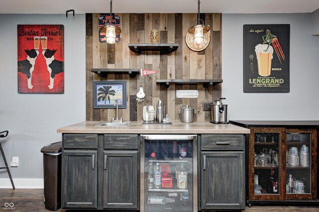 4644 Shelby Cir, Greenwood, IN 46143 - bar featuring indoor wet bar, baseboards, pendant lighting, beverage cooler, and a sink