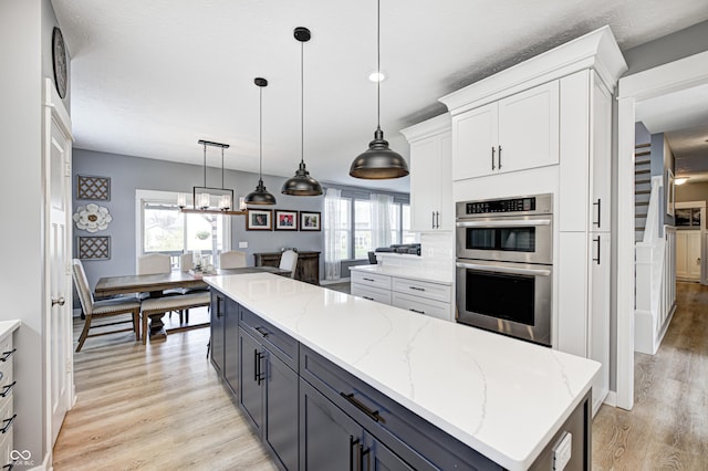 4644 Shelby Cir, Greenwood, IN 46143 - kitchen featuring light wood-style flooring, light stone counters, white cabinetry, and double oven
