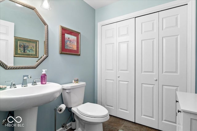 bathroom featuring a closet and toilet