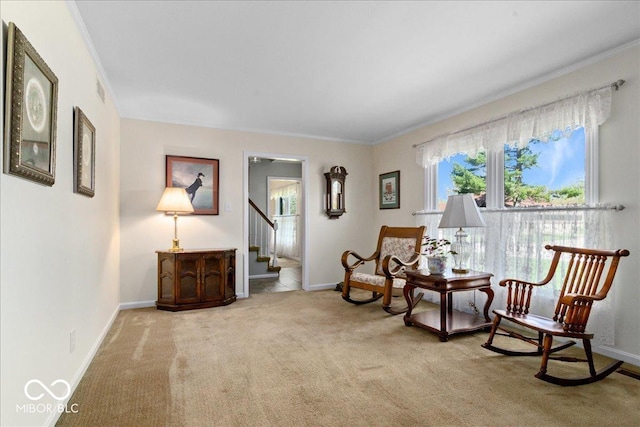 living area featuring crown molding, baseboards, carpet flooring, and stairs