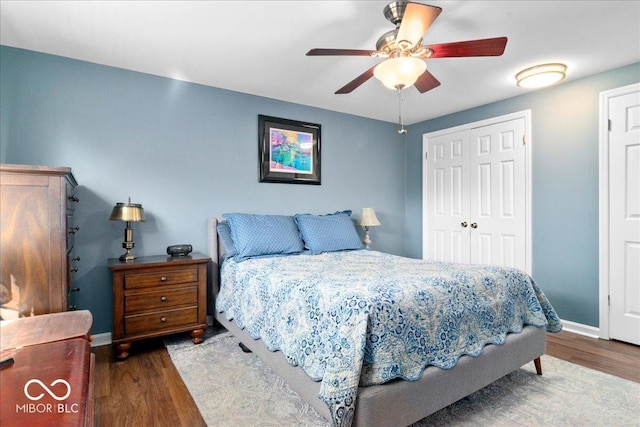 bedroom with a closet, baseboards, a ceiling fan, and wood finished floors